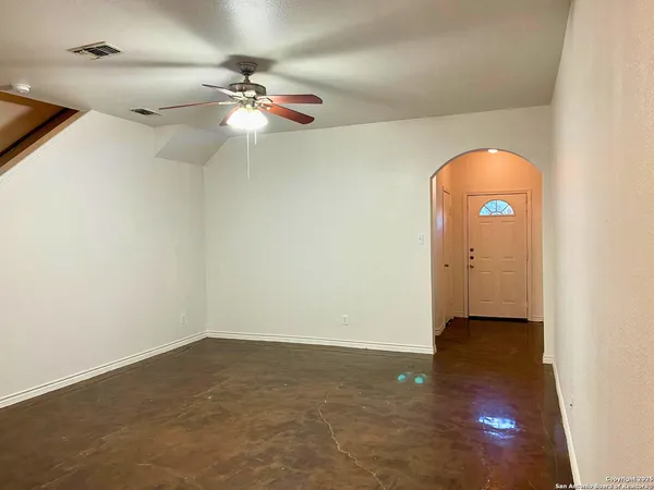 a view of a room with a ceiling fan and wooden floor