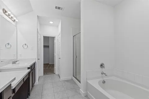 a spacious bathroom with a bathtub sink and mirror