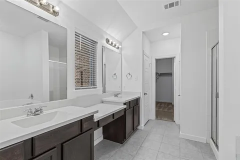 a spacious bathroom with a granite countertop sink a mirror and a bathtub