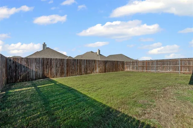 a view of a backyard with wooden fence