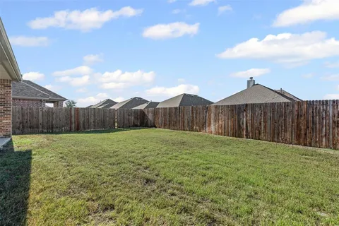 a view of a backyard with wooden fence
