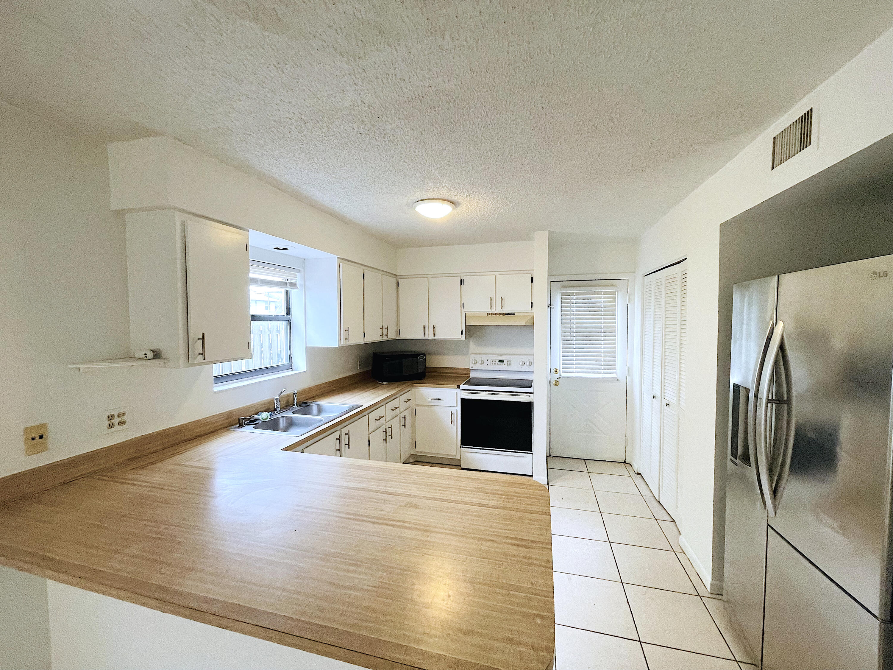 308 Hernando Street, Unit A Fort Pierce, FL 34949 - Photo 3 of 9 a kitchen with stainless steel appliances granite countertop a refrigerator and a sink
