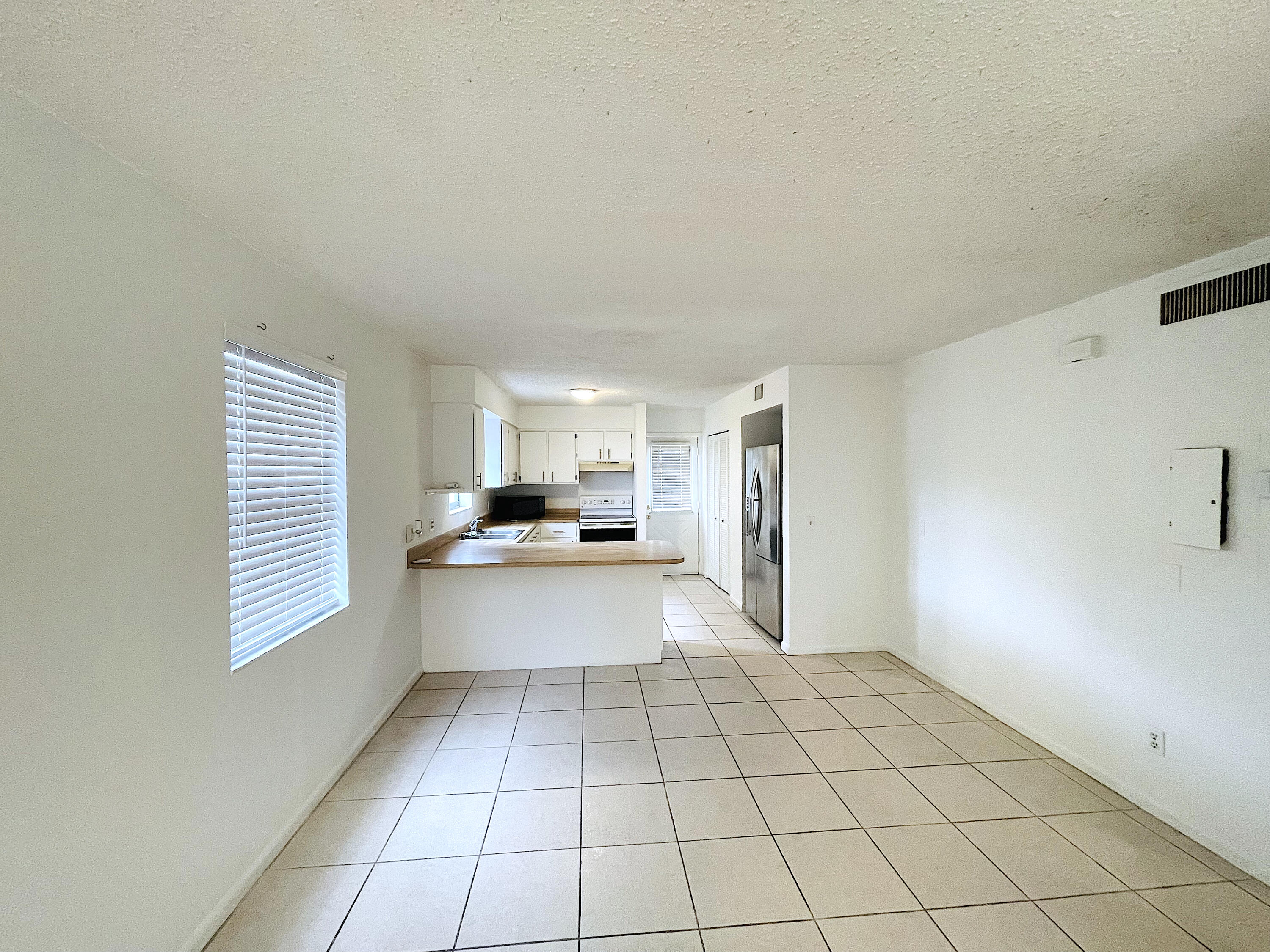 308 Hernando Street, Unit A Fort Pierce, FL 34949 - Photo 6 of 9 a view of a kitchen with kitchen island a sink wooden floor and a window
