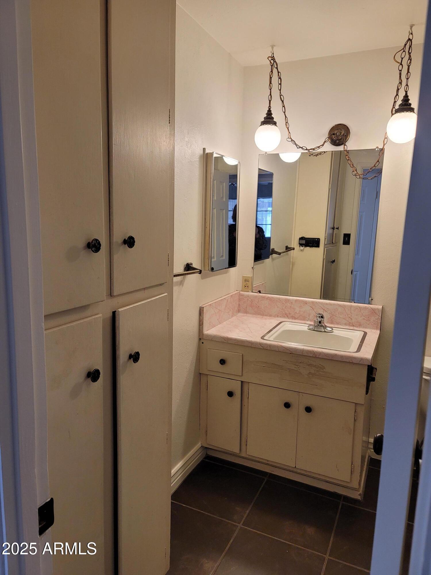 3926 West McLellan Boulevard Phoenix, AZ 85019 - Photo 12 of 14 a bathroom with a sink a vanity and a mirror