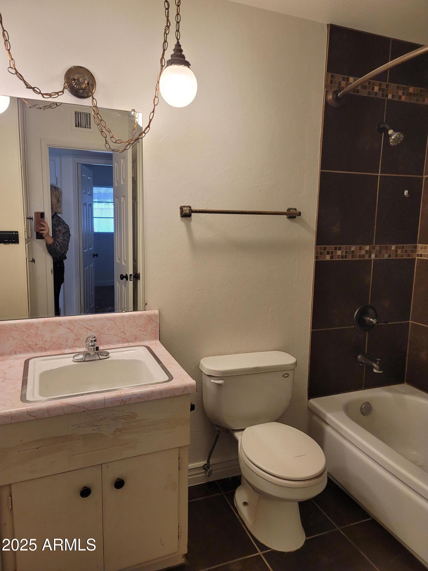 3926 West McLellan Boulevard Phoenix, AZ 85019 - Photo 13 of 14 a bathroom with a toilet a sink and shower