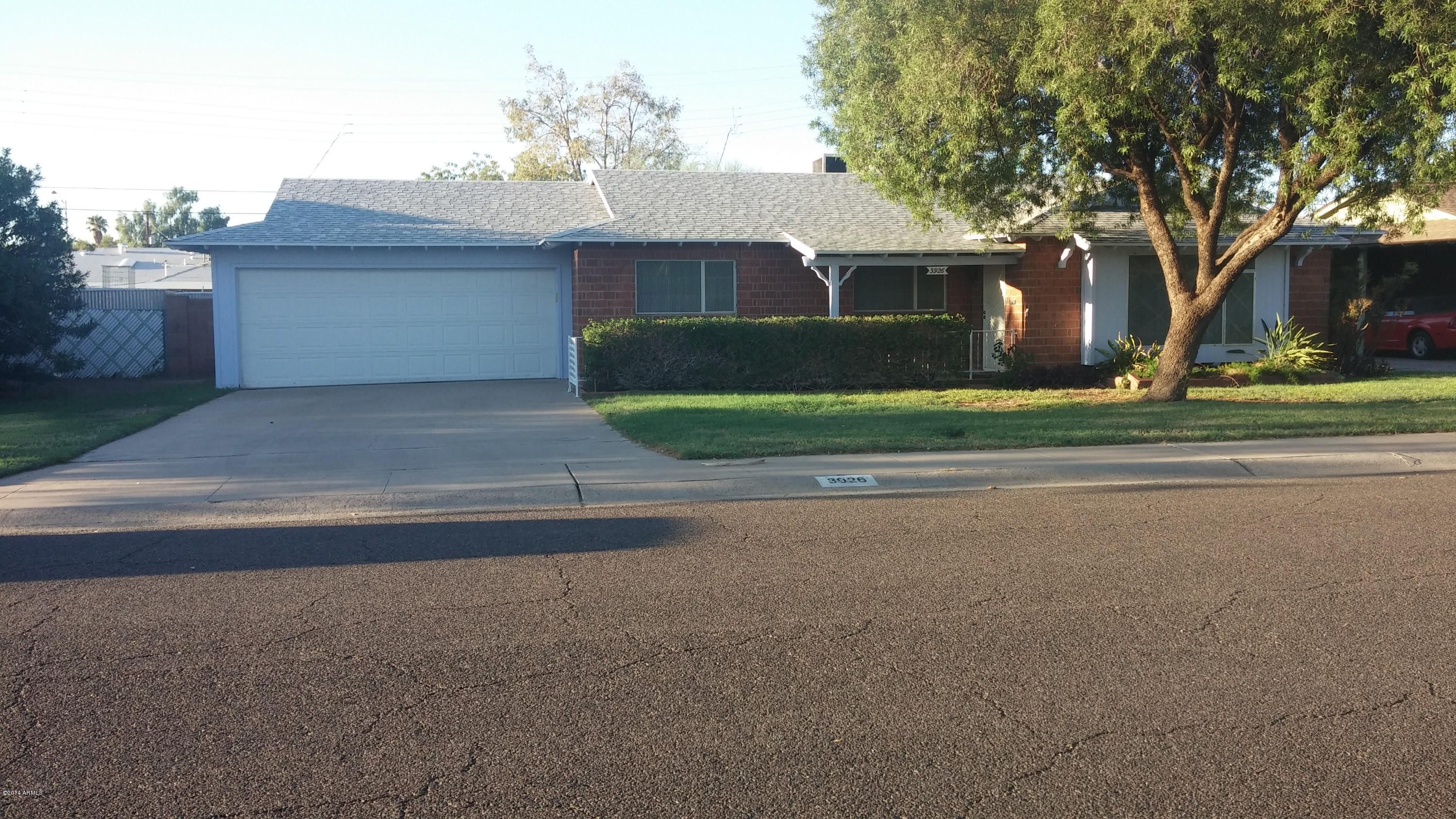 3926 West McLellan Boulevard Phoenix, AZ 85019 - Photo 2 of 14 a front view of a house with a yard and a garage