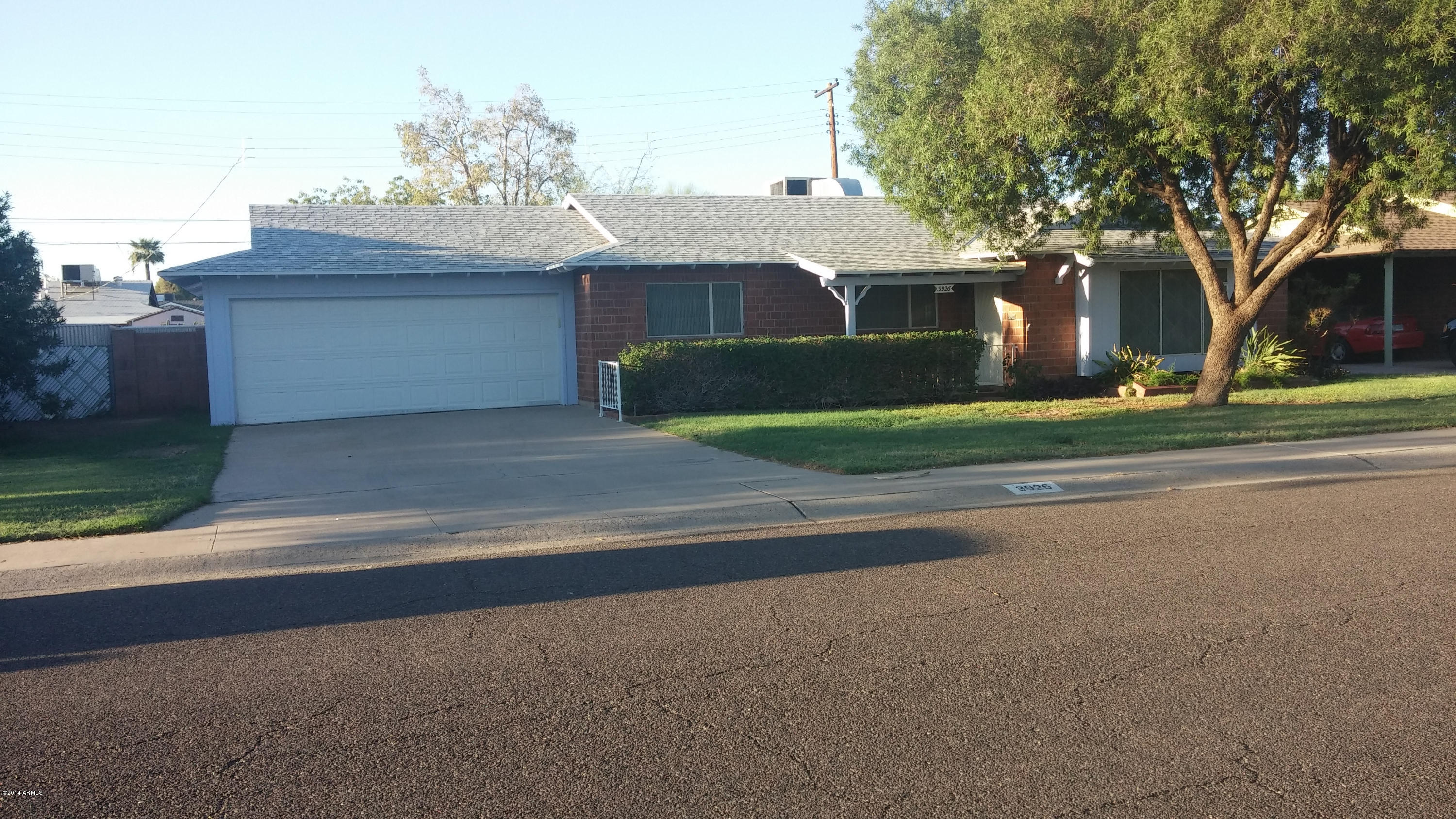 3926 West McLellan Boulevard Phoenix, AZ 85019 - Photo 3 of 14 a front view of a house with a yard and garage
