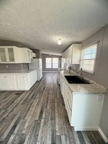 a kitchen with sink a stove and cabinets