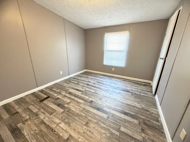 a view of empty room with wooden floor