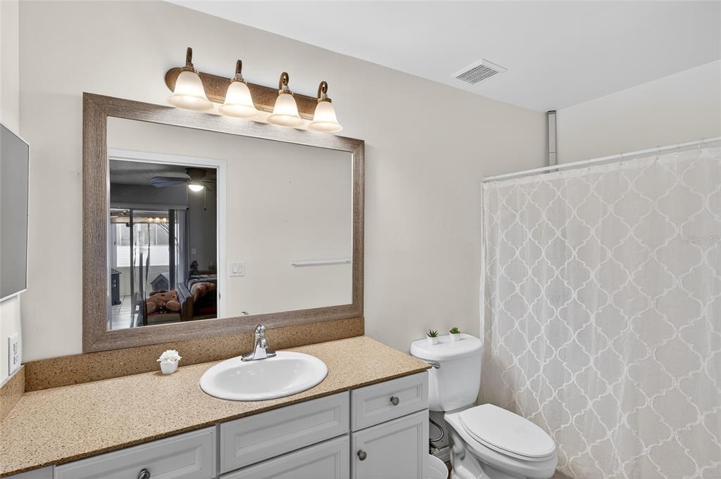622 Ridge Terrace Winter Haven, FL 33881 - Photo 22 of 29 a bathroom with a granite countertop sink and a mirror with toilet