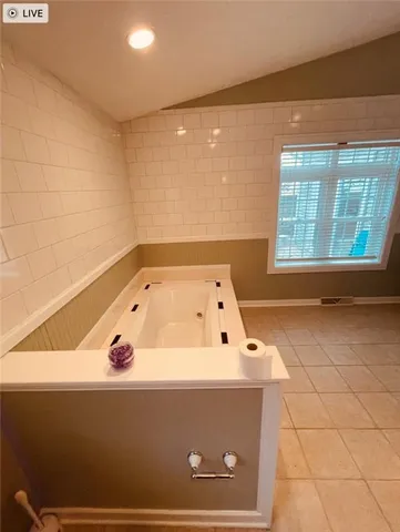 a bathroom with a tub and a window