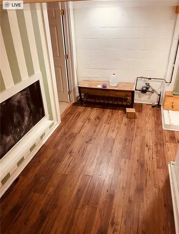a view of a living room with wooden floor and furniture