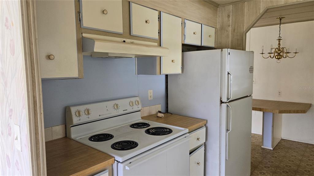 5921 Southwest 63rd Street Ocala, FL 34474 - Photo 6 of 24 a white refrigerator freezer and a stove sitting inside of a kitchen