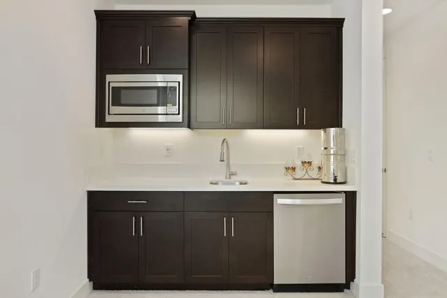 a view of a kitchen with a sink and a refrigerator