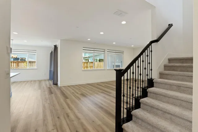 a kitchen with a sink stove and wooden floor
