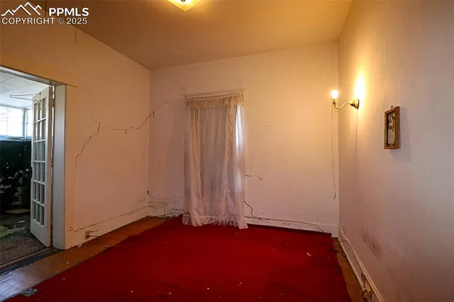 a view of an empty room with closet and a window