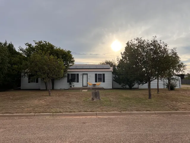 a front view of a house with a yard and trees