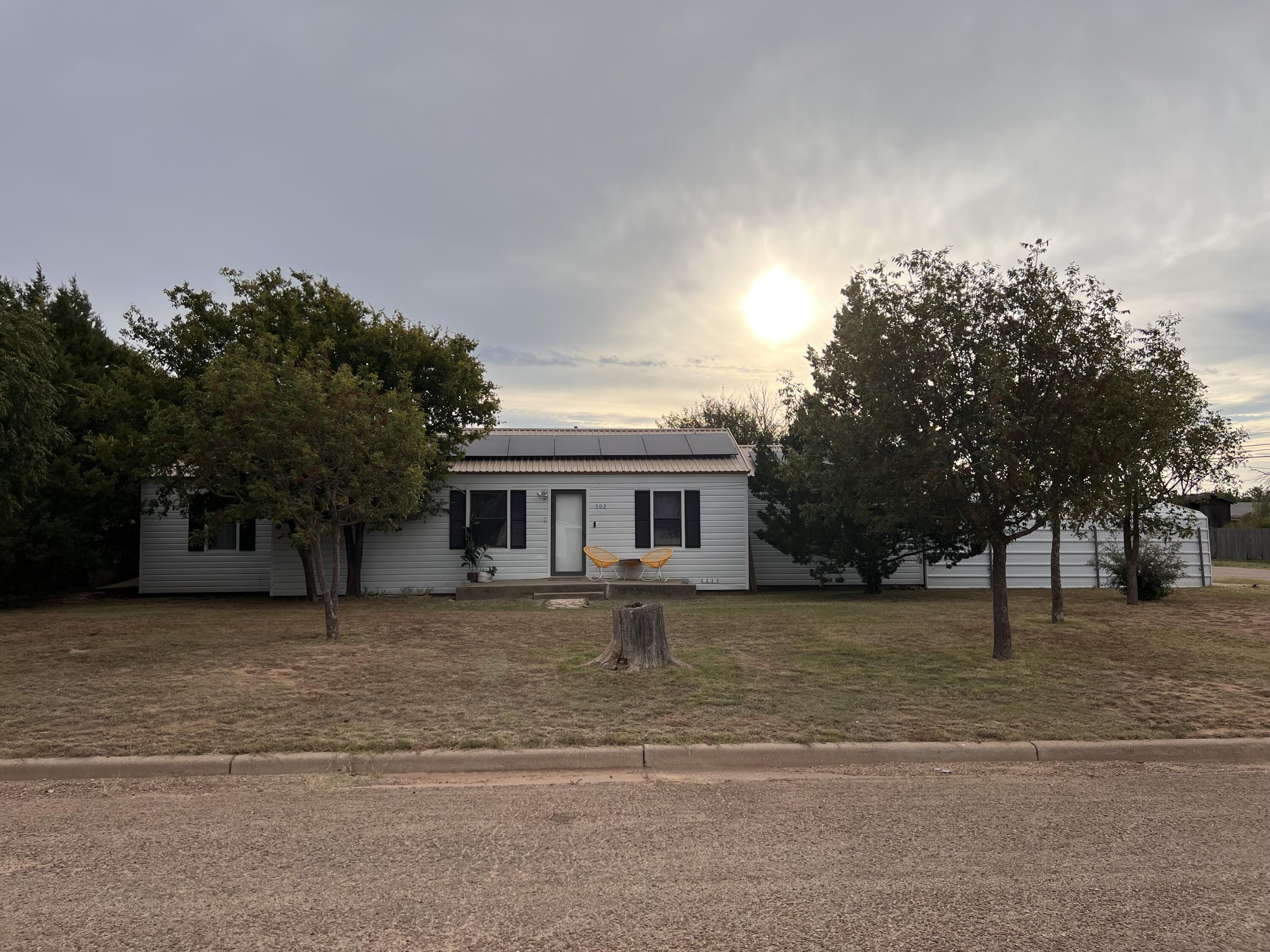 a front view of a house with a yard and trees