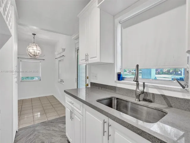 a kitchen with cabinets a sink and a stove with wooden floor