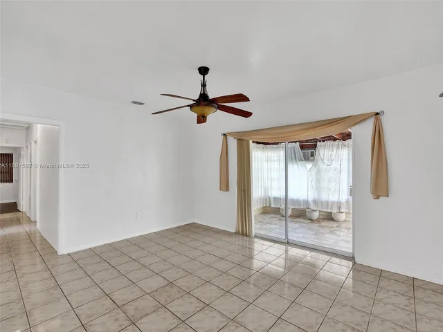 a view of a livingroom with a ceiling fan and window