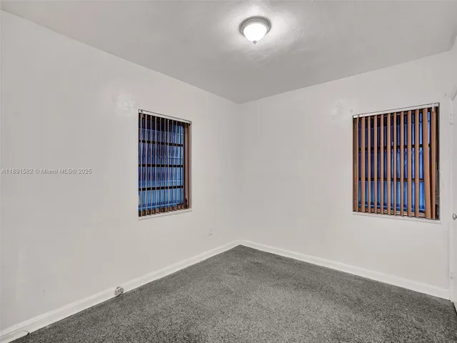 a view of an house with backyard and floor to ceiling window
