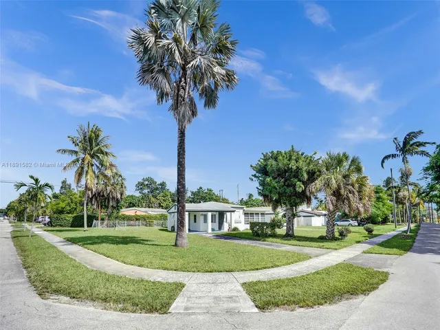 a front view of a house with a garden and trees