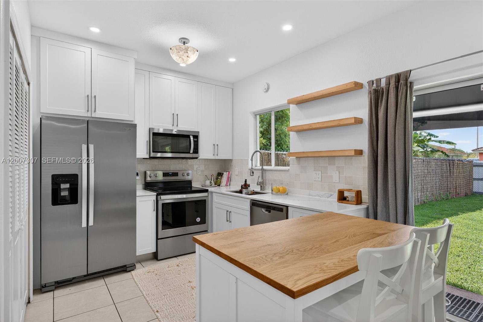 12310 Southwest 216th Street Miami, FL 33170 - Photo 10 of 22 a kitchen with stainless steel appliances granite countertop a refrigerator a stove top oven a sink and dishwasher