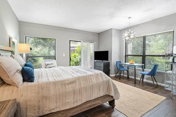 a bedroom with a bed and large windows
