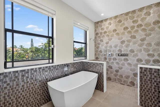 a en suite bathroom with a bathtub sink and mirror