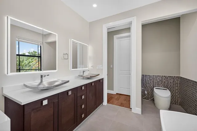 a hallway with a large mirror and cabinets