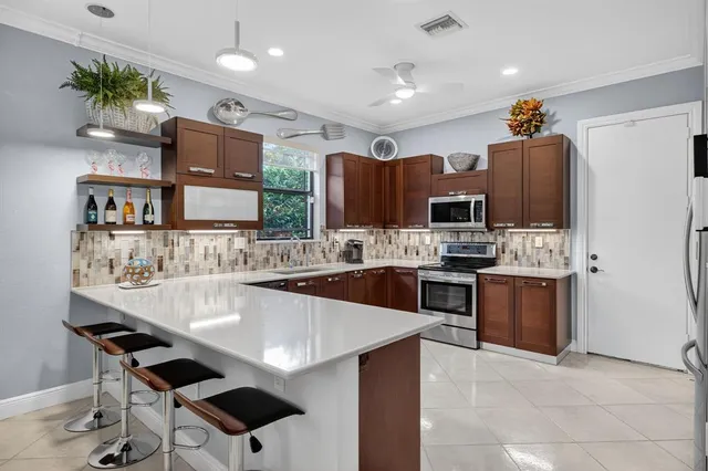 a kitchen with stainless steel appliances kitchen island granite countertop a stove refrigerator and a sink