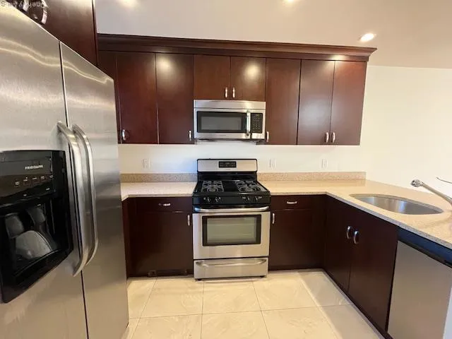 a kitchen with stainless steel appliances granite countertop a refrigerator and a sink
