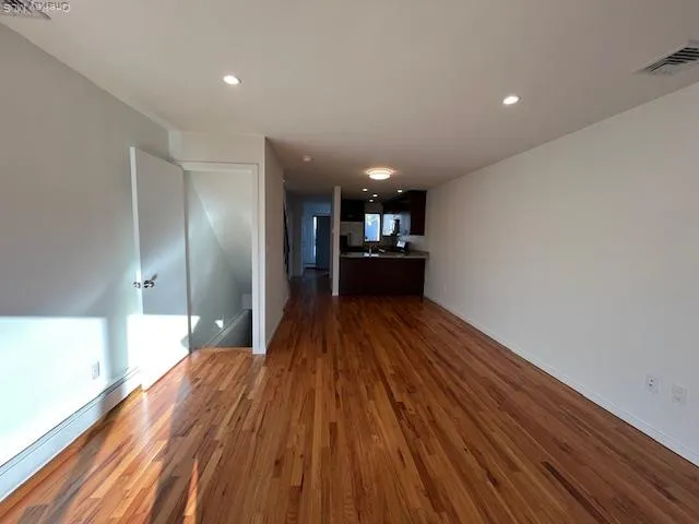 a view of a hallway with wooden floor and furniture