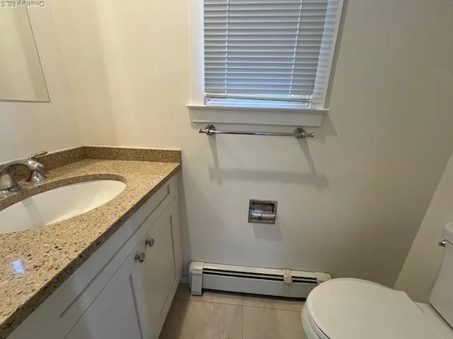 a bathroom with a granite countertop sink and a toilet