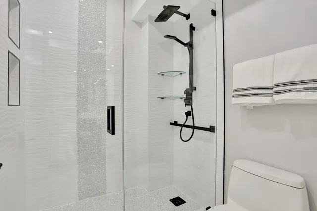 a bathroom with a sink a toilet and shower