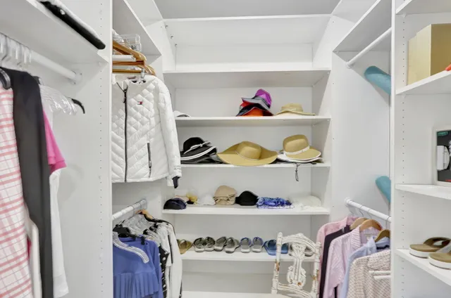 a view of walk in closet with clothes and shoes