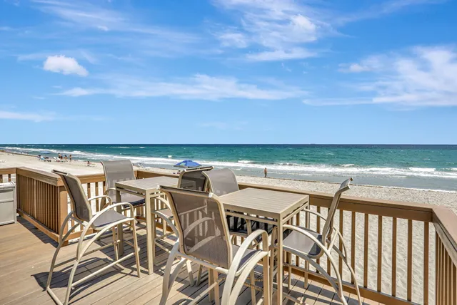a view of a patio with lawn chairs under an umbrella