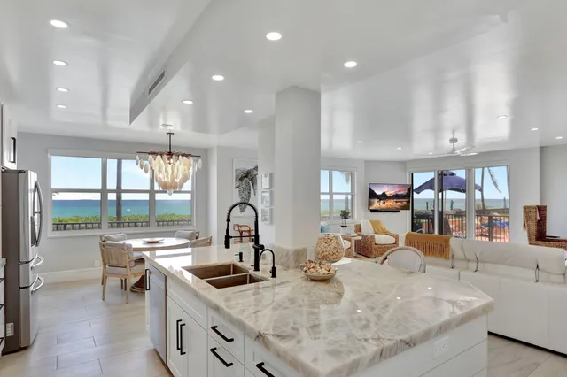 a kitchen with stainless steel appliances granite countertop a sink a stove and a refrigerator