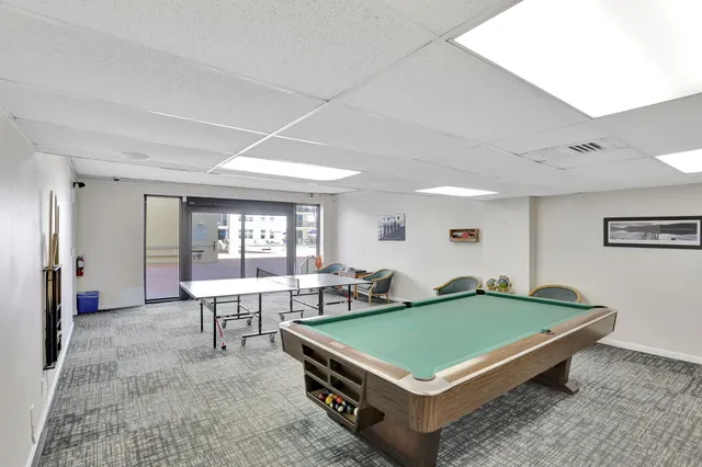 a living room with furniture pool table and a large window