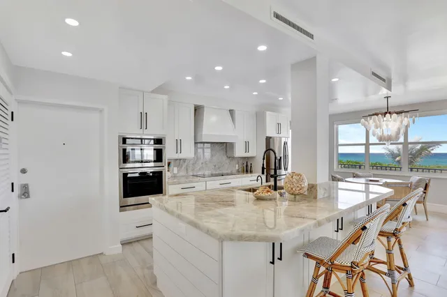 a kitchen with kitchen island granite countertop a sink and stainless steel appliances