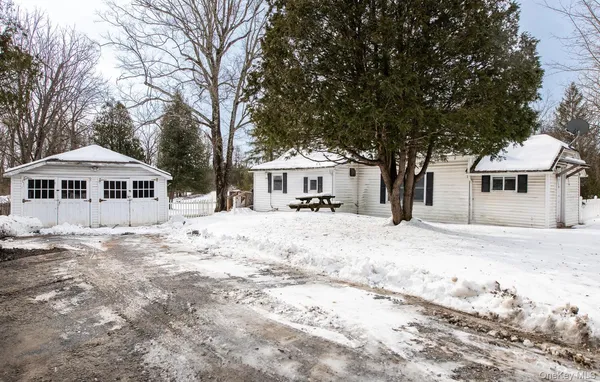 a front view of a house with a yard covered in snow