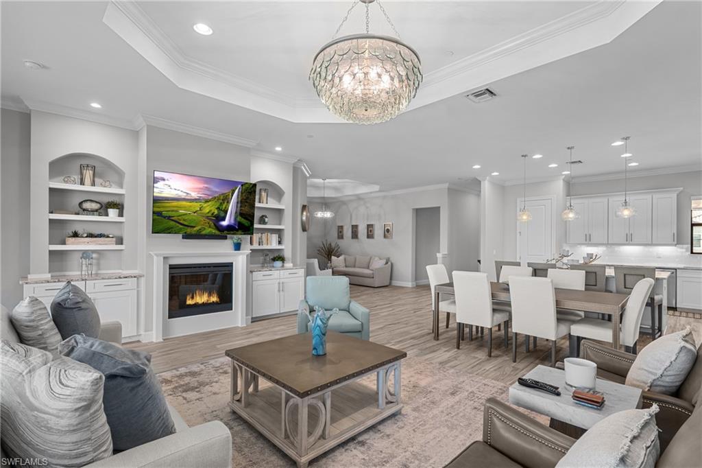 9673 Montelanico Loop, Unit 202 Naples, FL 34119 - Photo 1 of 46 a living room with furniture a fireplace and a chandelier