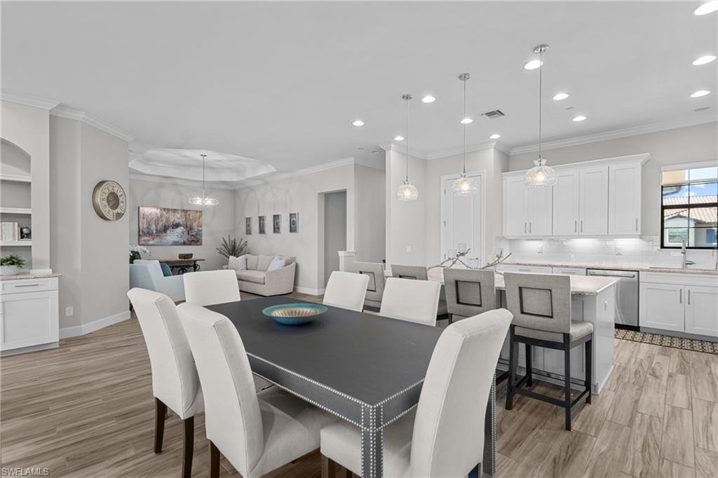 9673 Montelanico Loop, Unit 202 Naples, FL 34119 - Photo 11 of 46 a view of a dining room with furniture and wooden floor
