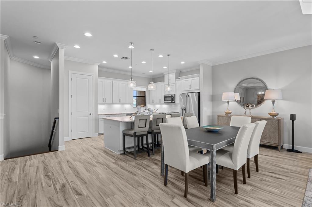 9673 Montelanico Loop, Unit 202 Naples, FL 34119 - Photo 12 of 46 a view of a dining room with furniture and wooden floor