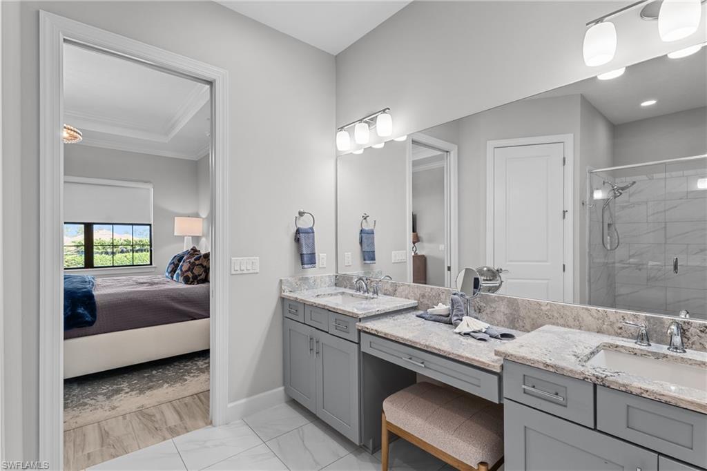 9673 Montelanico Loop, Unit 202 Naples, FL 34119 - Photo 15 of 46 a bathroom with a double vanity sink and a mirror