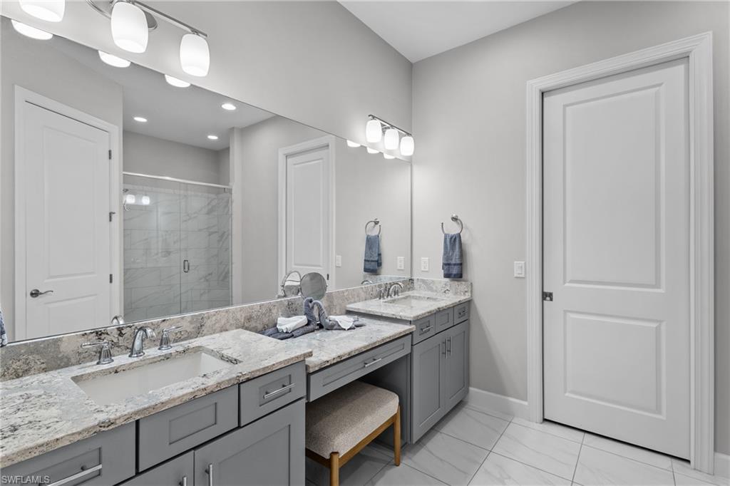 9673 Montelanico Loop, Unit 202 Naples, FL 34119 - Photo 16 of 46 a bathroom with a granite countertop double vanity sink and a mirror