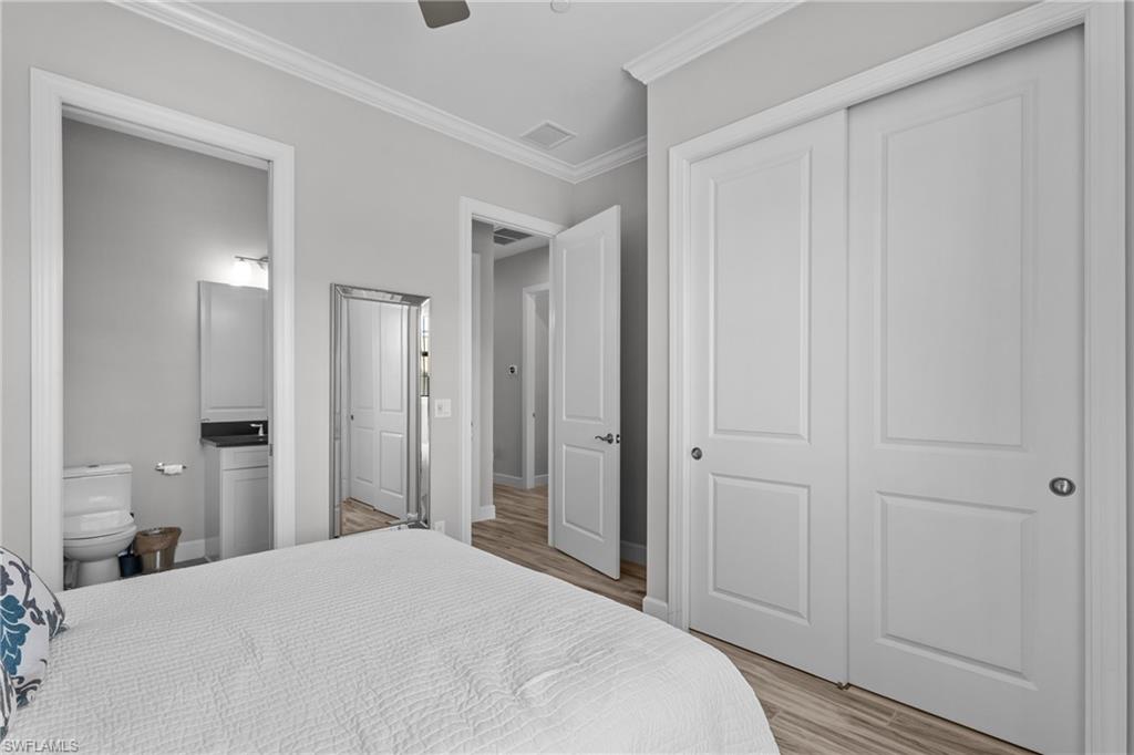 9673 Montelanico Loop, Unit 202 Naples, FL 34119 - Photo 18 of 46 a bedroom with a bed and cabinets