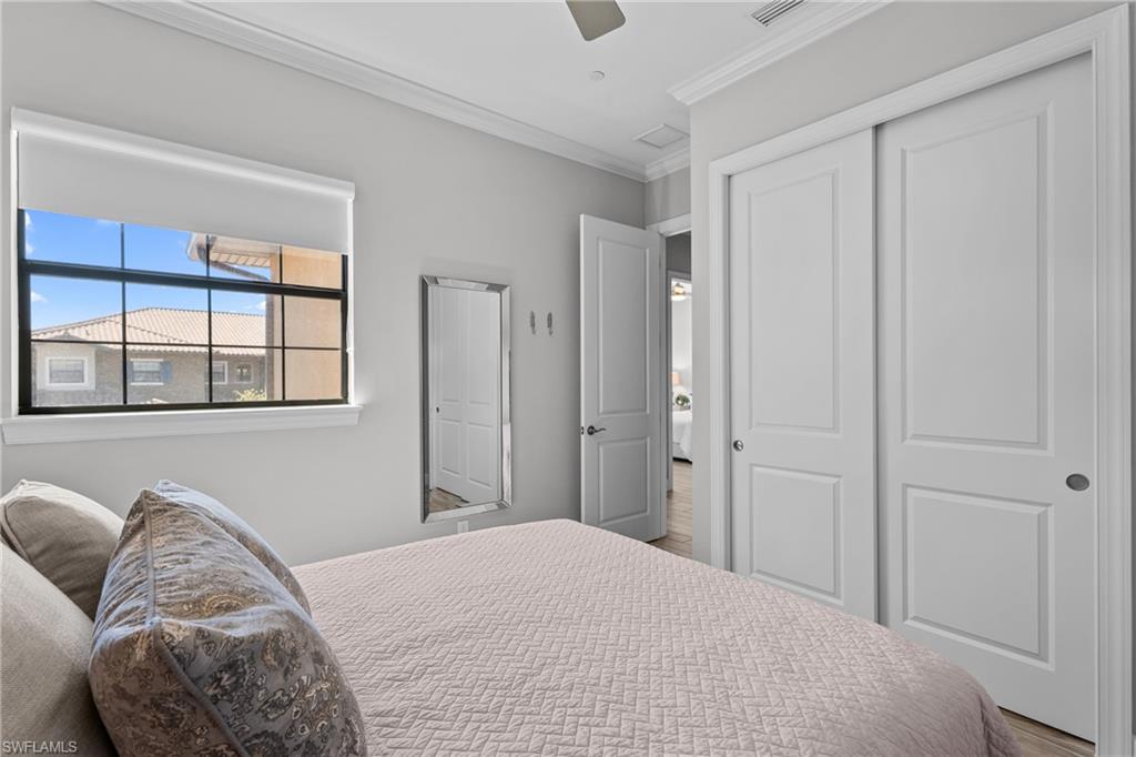 9673 Montelanico Loop, Unit 202 Naples, FL 34119 - Photo 21 of 46 a bedroom with a bed and a window