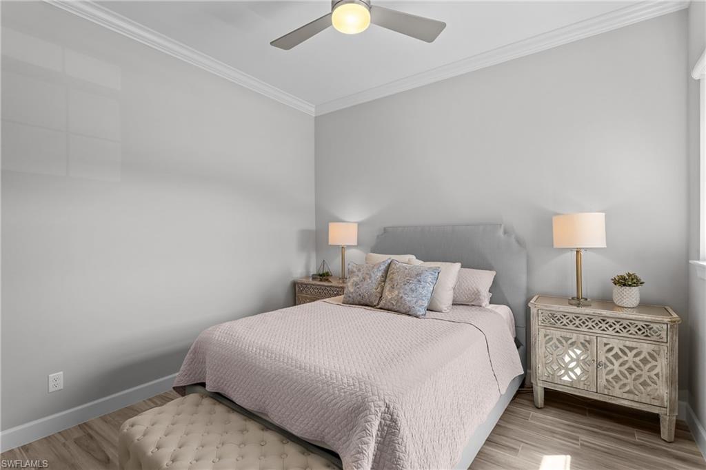 9673 Montelanico Loop, Unit 202 Naples, FL 34119 - Photo 22 of 46 a bedroom with a bed and a lamp