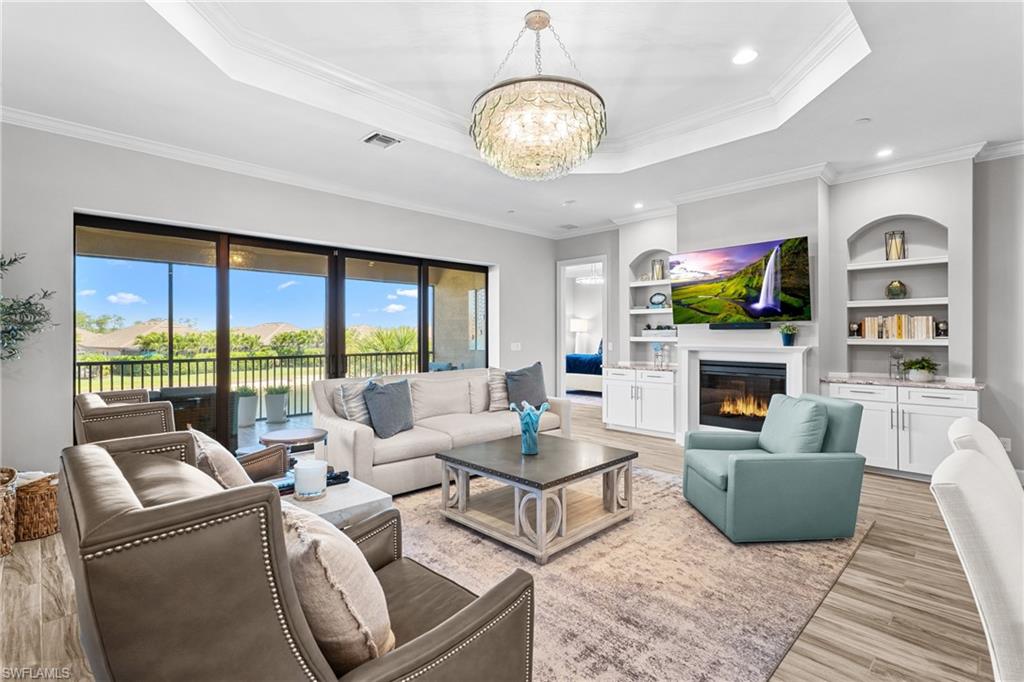 9673 Montelanico Loop, Unit 202 Naples, FL 34119 - Photo 3 of 46 a living room with fireplace furniture and a large window